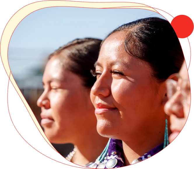 Three women with eyes closed, basking in sunlight, framed by a red heart shape.