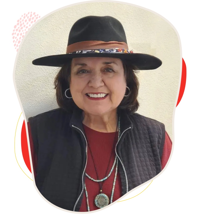 Smiling woman wearing a black hat and layered necklaces.