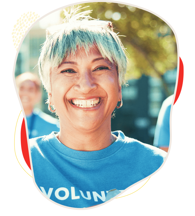 Smiling volunteer with short hair enjoying a sunny day outdoors.